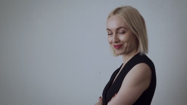 Hermosa mujer adulta sonriendo y se encoge de hombros en vestido negro . — Vídeo de stock