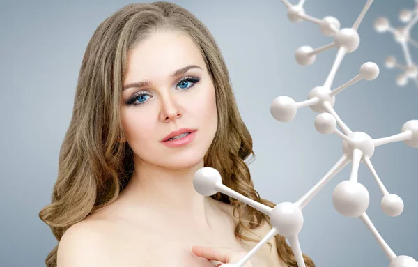 Beautiful woman near big white molecule chain. — Stock Photo, Image