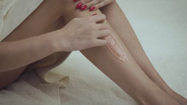 Las piernas femeninas enceradas se pegan en el spa . — Vídeo de stock