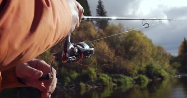 Manos de pescador lanzando caña de pescar y enrollándola . — Vídeo de stock