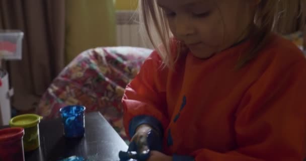 Lycklig liten flicka med händer i blå färg ritning — Stockvideo