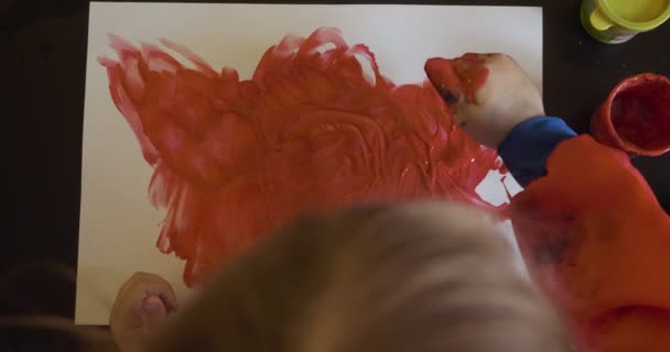 Happy little girl with hands in red paint drawing — Stock Video