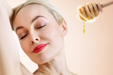 Genç kadın ve bal kaşığı yüz maskesi hazırlamak.