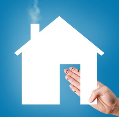 Parmaklarında emoji olan kadın eli beyaz kağıt ev tutuyor..