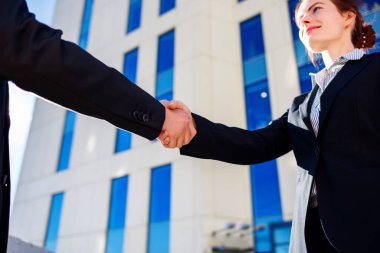 İş adamlarının el sıkışması şehir binalarının arka planında
