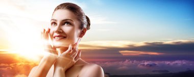 Double exposure of beautiful woman face and sunset sky.