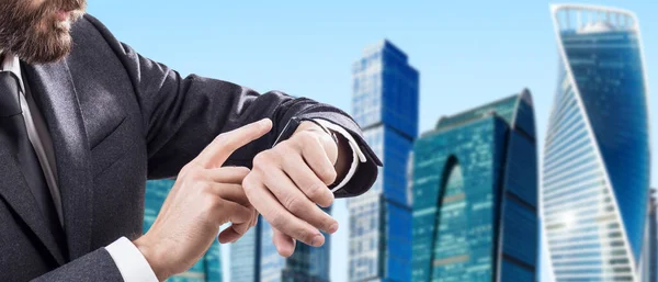 Businessman check smartwatch over cityscape background. — Stock Photo, Image