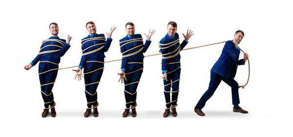 Hombre de negocios enojado tira de sí mismo atado con una cuerda . — Foto de Stock