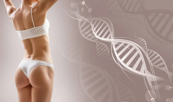 Sportieve vrouwelijke lichaam in de buurt van DNA stengels. Over beige achtergrond. — Stockfoto