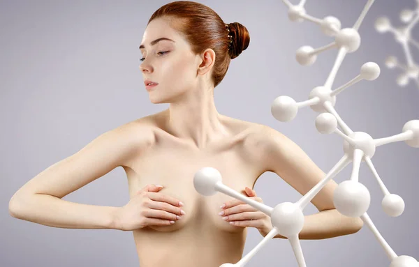 Jeune femme nue couvrir seins parmi la chaîne de molécules de verre . — Photo