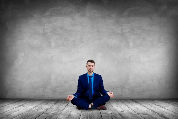 Calm businessman sitting in lotus pose and meditating. — Stock Photo, Image