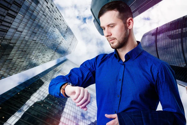 Businessman check smartwatch over cityscape background. — Stock Photo, Image