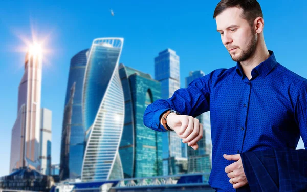 Businessman check smartwatch over cityscape background. — Stock Photo, Image