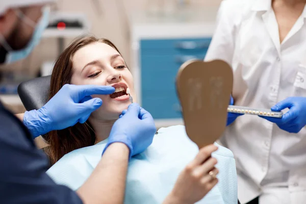 Odcień zębów pacjenta z próbkami do zabiegu wybielania. — Zdjęcie stockowe