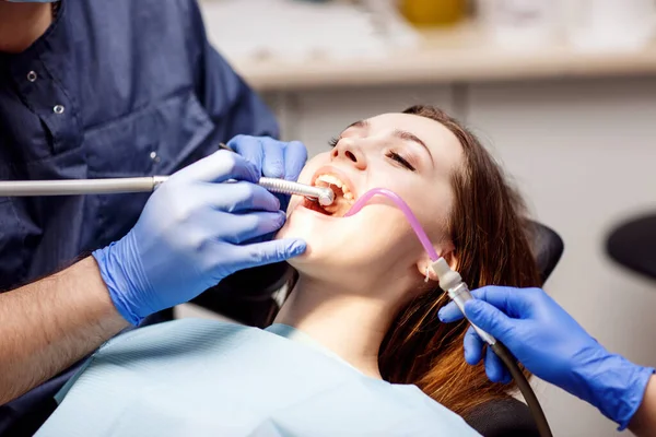 Dentysta leczący zęby młodej pacjentce w klinice. — Zdjęcie stockowe