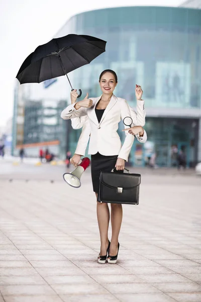 Ung affärskvinna multitasking med olika personal i händerna. — Stockfoto