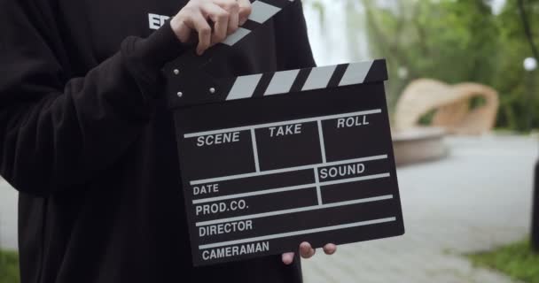 Unrecognizable man with clapperboard leaves the video frame. — Stockvideo