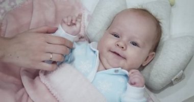 Annenin eli yeni doğan bebeğine beşiğinde dokunur..