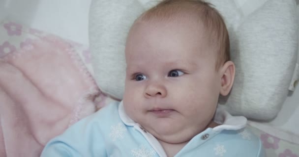 Malé roztomilé novorozeně leží na zádech v postýlce. — Stock video