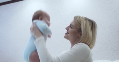 Anne, bebeğini kollarında sıkıca okşar..