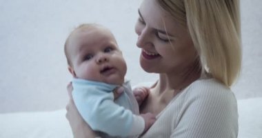 Mutlu anne bebeğini kucağında, sarılıp öpüyor..