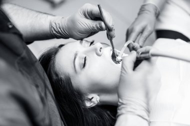 Dişçi klinikteki genç kadın hastaları tedavi ediyor..