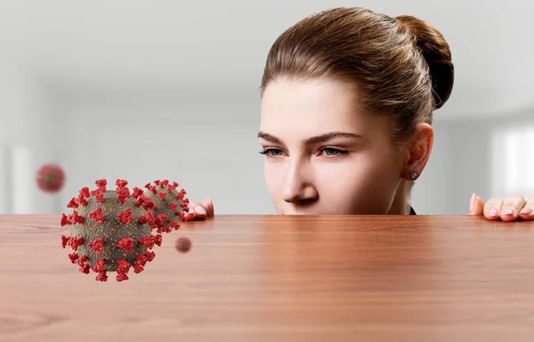 Vrouw met argwaan kijkt naar het coronavirus onder de rand van de tafel. — Stockfoto