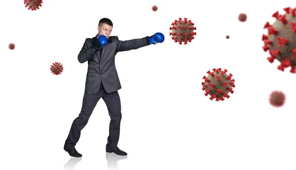 ボクシンググローブのビジネスマンがコロナウイルス細胞をパンチ. — ストック写真