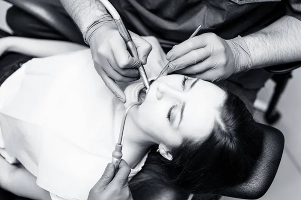 Dişçi klinikteki genç kadın hastaları tedavi ediyor..