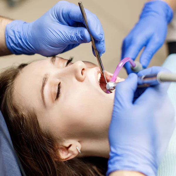 Dişçi klinikteki genç kadın hastaları tedavi ediyor..