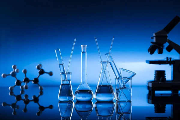 Laboratory concept, blue background, beakers — Stock Photo, Image