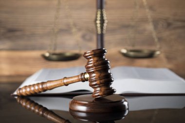 Ölçek adalet, tokmak ve ahşap arka plan üzerinde kitap.