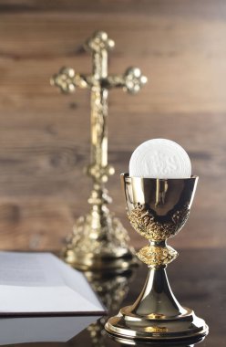 Katolik dini Tema. Çapraz, Holy Bible ve ahşap zemin üzerine altın kadeh.