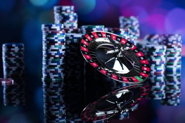 Casino Tema. Casino rulet ve poker chipi tüm renkli bokeh arka plan üzerinde bir oyun Masa üzerinde yüksek kontrast görüntü. Tipografi ve logo için yer.