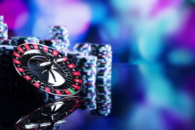 Casino Tema. Casino rulet ve poker chipi tüm renkli bokeh arka plan üzerinde bir oyun Masa üzerinde yüksek kontrast görüntü. Tipografi ve logo için yer.