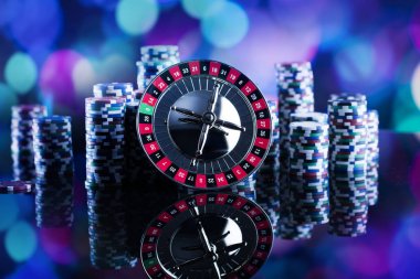 Casino Tema. Casino rulet ve poker chipi tüm renkli bokeh arka plan üzerinde bir oyun Masa üzerinde yüksek kontrast görüntü. Tipografi ve logo için yer.