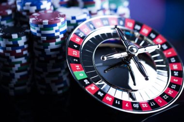 Casino Tema. Casino rulet ve poker chipi tüm renkli bokeh arka plan üzerinde bir oyun Masa üzerinde yüksek kontrast görüntü. Tipografi ve logo için yer.