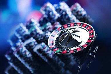 Casino Tema. Casino rulet ve poker chipi tüm renkli bokeh arka plan üzerinde bir oyun Masa üzerinde yüksek kontrast görüntü. Tipografi ve logo için yer.