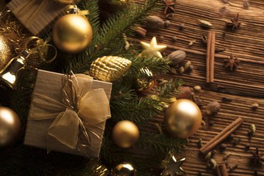Noel dekorasyonu ile altın ve kahverengi estetik sunar kutuları, altın baubles, Noel baharat tüm kopya alanı bir rustik ahşap zemin üzerine.