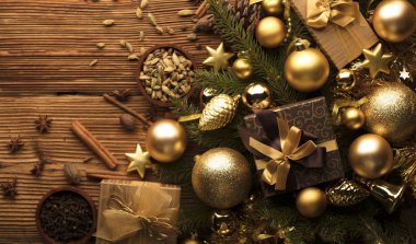 Noel dekorasyonu ile altın ve kahverengi estetik sunar kutuları, altın baubles, Noel baharat tüm kopya alanı bir rustik ahşap zemin üzerine.