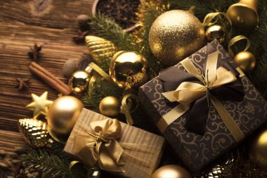 Noel dekorasyonu ile altın ve kahverengi estetik sunar kutuları, altın baubles, Noel baharat tüm kopya alanı bir rustik ahşap zemin üzerine.