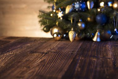 Noel süsleri-mavi ve altın estetik, rustik ahşap masa. Metin için yer.