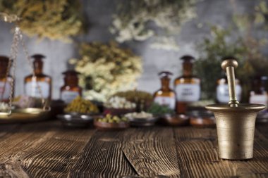 Doğal Tıp arka plan. Pirinç harç, ölçek. Rustik tablo. Çeşitli kuru otlar kase. Bokeh.