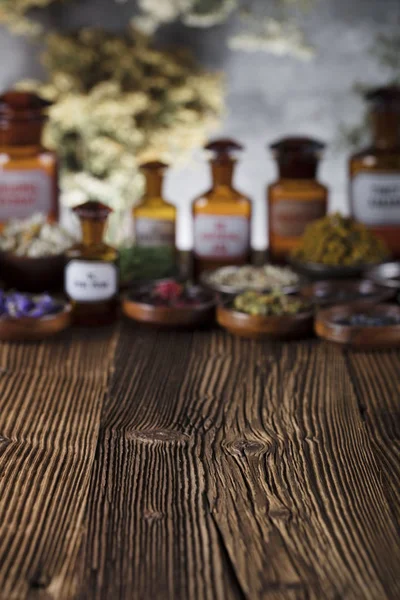 Natural medicine background. Brass mortar, scale. Rustic table. Assorted dry herbs in bowls. Bokeh.