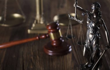 Adalet ve bir taş arka plan ve rustik ahşap masa hakimin tokmak heykeli.