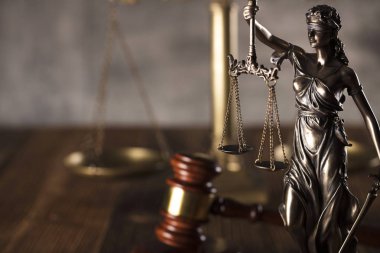 Adalet ve bir taş arka plan ve rustik ahşap masa hakimin tokmak heykeli.