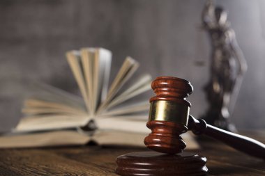 Adalet ve bir taş arka plan ve rustik ahşap masa hakimin tokmak heykeli.