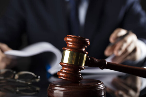 Судья подписывает документ. Молоток на стеклянном столе. Тема права и справедливости
.