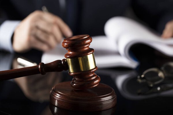 Судья подписывает документы в зале суда. Молоток на стол. Тема права и справедливости
.