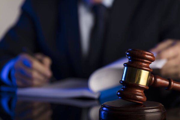 Судья подписывает документы в зале суда. Молоток на стол. Тема права и справедливости
.